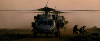 Movie still from “Act of Valor” (2012), directed by Scott Waugh – A helicopter is parked in the sand on a beach; Wide shot, Low angle