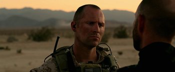 Movie still from “Act of Valor” (2012), directed by Scott Waugh – A man in a military uniform is looking at the camera; Close Up shot, Over the shoulder angle