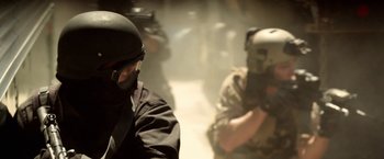 Movie still from “Act of Valor” (2012), directed by Scott Waugh – A group of men in military gear in a room; Close Up shot, Over the shoulder angle