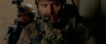 Movie still from “Act of Valor” (2012), directed by Scott Waugh – A man with a rifle in his hand; Close Up shot, Low angle