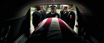 Movie still from “Act of Valor” (2012), directed by Scott Waugh – A group of men standing next to an american flag draped casket; Wide shot, Low angle