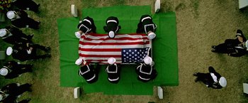 Movie still from “Act of Valor” (2012), directed by Scott Waugh – An overhead view of a group of people sitting around an american flag; Wide shot, Overhead angle