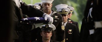 Movie still from “Act of Valor” (2012), directed by Scott Waugh – A group of men in military uniforms standing next to each other holding a flag; Medium shot, Low angle