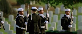 Movie still from “Act of Valor” (2012), directed by Scott Waugh – A group of men in uniform holding guns in front of a cemetery; Wide shot, High angle