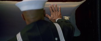 Movie still from “Act of Valor” (2012), directed by Scott Waugh – A man in a military uniform raises his hand; Extreme Close Up shot, Over the shoulder angle