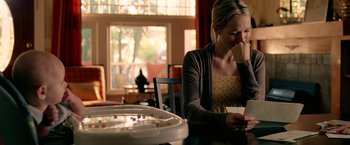 Movie still from “Act of Valor” (2012), directed by Scott Waugh – A woman sitting at a dining room table looking at a laptop; Close Up shot, Over the shoulder angle