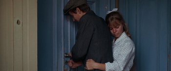 A man and a woman standing in front of a door
