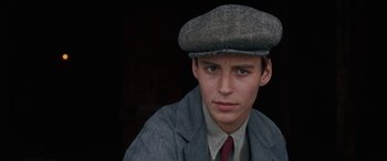 A young man wearing a hat and a tie