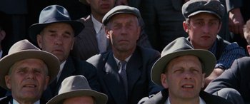 An older man wearing a suit and a hat