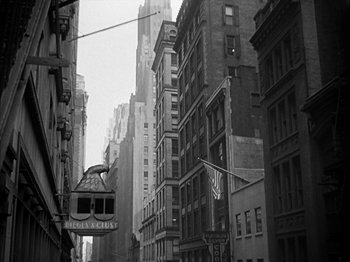 Movie still from “Adam's Rib” (1949), directed by George Cukor – A black - and - white photo of buildings in a city; Extreme Wide shot, Low angle