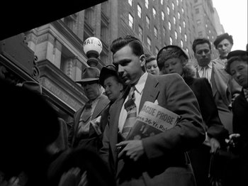 Movie still from “Adam's Rib” (1949), directed by George Cukor – Black and white photograph of people walking down a street; Medium shot, Low angle