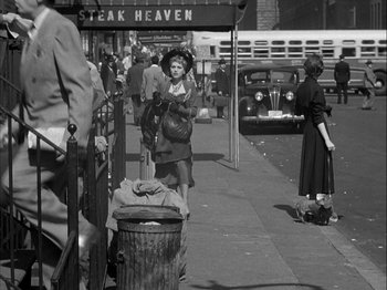 Movie still from “Adam's Rib” (1949), directed by George Cukor – An older woman walking down the street with a purse; Wide shot, High angle