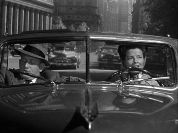 Movie still from “Adam's Rib” (1949), directed by George Cukor – A man and a woman in the driver's seat of an old car; Medium shot, Low angle