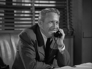 Movie still from “Adam's Rib” (1949), directed by George Cukor – An older man sitting at a table talking on a phone; Medium shot, Low angle