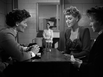 Movie still from “Adam's Rib” (1949), directed by George Cukor – Two women sitting at a table in front of each other; Medium shot, Over the shoulder angle