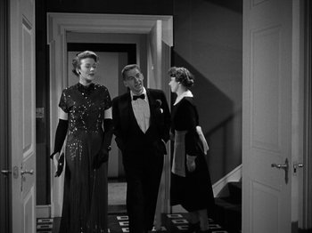 Movie still from “Adam's Rib” (1949), directed by George Cukor – Two women and a man are standing in front of a doorway; Medium shot, Low angle