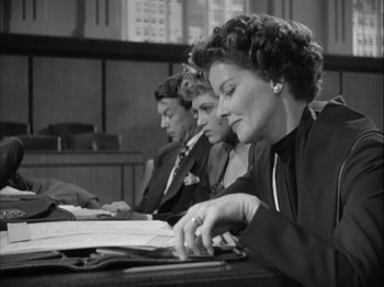 Movie still from “Adam's Rib” (1949), directed by George Cukor – A group of people sitting at a table with papers on it; Medium shot, Low angle