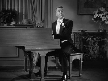 Movie still from “Adam's Rib” (1949), directed by George Cukor – A black and white photo of a man sitting at a piano; Medium shot, High angle