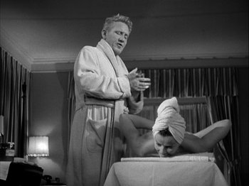 Movie still from “Adam's Rib” (1949), directed by George Cukor – An old photo of a man giving a woman a massage; Medium shot, Low angle