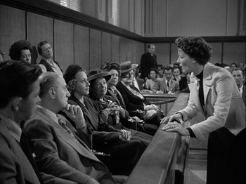Movie still from “Adam's Rib” (1949), directed by George Cukor – An old black and white photo of people in a court room; Medium shot, Low angle