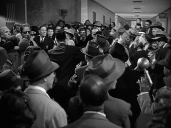Movie still from “Adam's Rib” (1949), directed by George Cukor – Black and white photograph of a group of men in hats; Extreme Wide shot, High angle