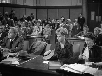 Movie still from “Adam's Rib” (1949), directed by George Cukor – A black and white photo of people sitting in a courtroom; Medium shot, High angle