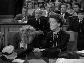 Movie still from “Adam's Rib” (1949), directed by George Cukor – Two women sitting at a table in front of a crowd; Medium shot, Low angle