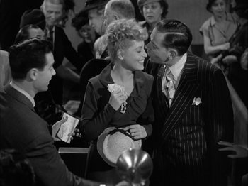 Movie still from “Adam's Rib” (1949), directed by George Cukor – A man and a woman are talking to each other in a crowd; Medium shot, High angle