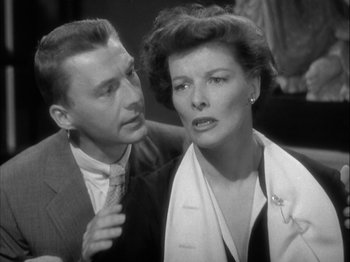 Movie still from “Adam's Rib” (1949), directed by George Cukor – An older man standing next to an older woman; Close Up shot, Over the shoulder angle