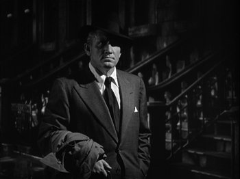 Movie still from “Adam's Rib” (1949), directed by George Cukor – A black and white photo of a man in a suit and tie; Medium shot, Low angle