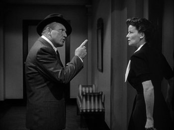 Movie still from “Adam's Rib” (1949), directed by George Cukor – An older man in a suit and a woman in a dress suit; Medium shot, Over the shoulder angle