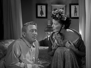 Movie still from “Adam's Rib” (1949), directed by George Cukor – An older man and a young woman sitting on a couch; Medium shot, Low angle