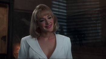 Movie still from “Addams Family Values” (1993), directed by Barry Sonnenfeld – A woman with blonde hair wearing a white jacket; Close Up shot, Over the shoulder angle