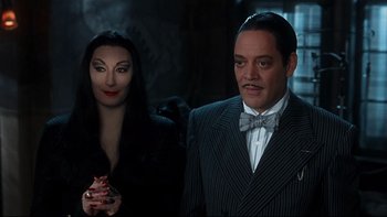 Movie still from “Addams Family Values” (1993), directed by Barry Sonnenfeld – Gomez and morticia addams in the addams family; Medium shot, Over the shoulder angle