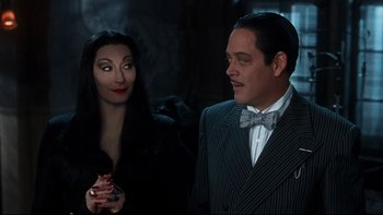 Movie still from “Addams Family Values” (1993), directed by Barry Sonnenfeld – A man and a woman dressed up in costume; Medium shot, Over the shoulder angle