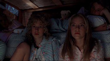 Movie still from “Addams Family Values” (1993), directed by Barry Sonnenfeld – Two young girls in their pajamas in a bed; Medium shot, Low angle