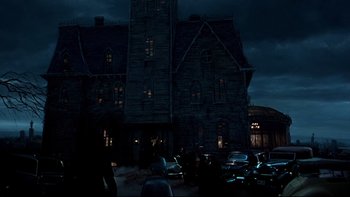 Movie still from “Addams Family Values” (1993), directed by Barry Sonnenfeld – A group of cars parked in front of a building at night; Extreme Wide shot, Low angle