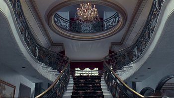 Movie still from “Addams Family Values” (1993), directed by Barry Sonnenfeld – A chandelier hangs above a staircase in a building; Extreme Wide shot, High angle