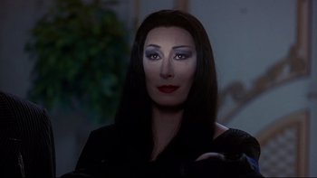 Movie still from “Addams Family Values” (1993), directed by Barry Sonnenfeld – A person wearing a costume; Close Up shot, Over the shoulder angle