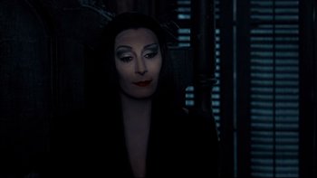 Movie still from “Addams Family Values” (1993), directed by Barry Sonnenfeld – A person wearing a costume; Close Up shot, Over the shoulder angle