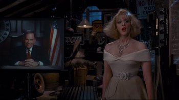 Movie still from “Addams Family Values” (1993), directed by Barry Sonnenfeld – A woman in a white dress standing in a room; Medium shot, Over the shoulder angle