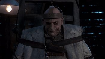 Movie still from “Addams Family Values” (1993), directed by Barry Sonnenfeld – A man in a suit and a hat is holding a pair of scissors in his hands; Close Up shot, Low angle