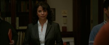 Movie still from “Admission” (2013), directed by Paul Weitz – A woman wearing a suit and tie standing in a room; Close Up shot, High angle