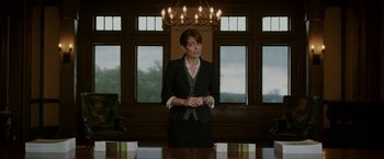 Movie still from “Admission” (2013), directed by Paul Weitz – A woman standing in front of a table; Medium shot, Over the shoulder angle