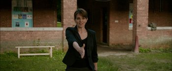 Movie still from “Admission” (2013), directed by Paul Weitz – A woman in a black jacket holding out her hand; Medium shot, Over the shoulder angle