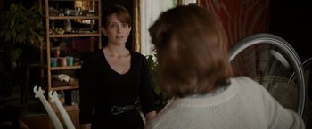 Movie still from “Admission” (2013), directed by Paul Weitz – A woman standing in front of a man in front of a mirror; Medium shot, Over the shoulder angle