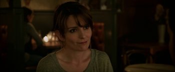 Movie still from “Admission” (2013), directed by Paul Weitz – A person wearing a gray t - shirt; Close Up shot, Over the shoulder angle