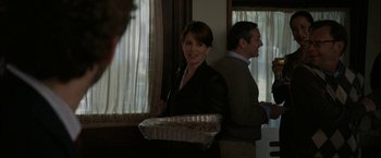 Movie still from “Admission” (2013), directed by Paul Weitz – A man and woman standing in front of a window holding food; Medium shot, Over the shoulder angle