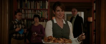 Movie still from “Admission” (2013), directed by Paul Weitz – A woman holding a tray of food in front of a group of people; Medium shot, Over the shoulder angle