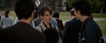 Movie still from “Admission” (2013), directed by Paul Weitz – A woman standing next to a crowd of people; Close Up shot, Over the shoulder angle